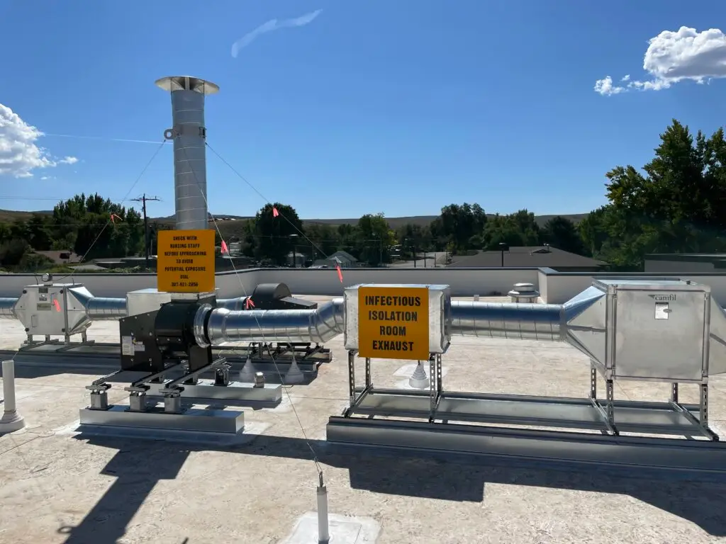 Rooftop infectious isolation room exhaust system installed at Hot Springs County Hospital featuring new exhaust fans, ductwork, and negative pressure ventilation upgrades completed within an active healthcare facility.
